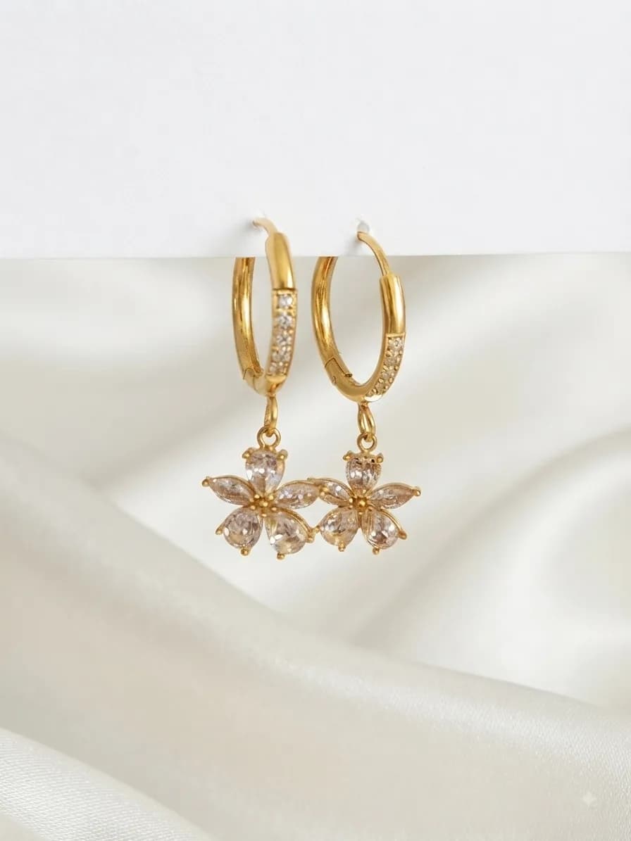 Gold-plated huggie hoops with crystal flower drops, on ivory silk