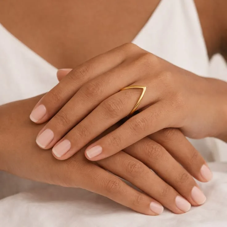 A model wearing a plain gold-plated chevron ring