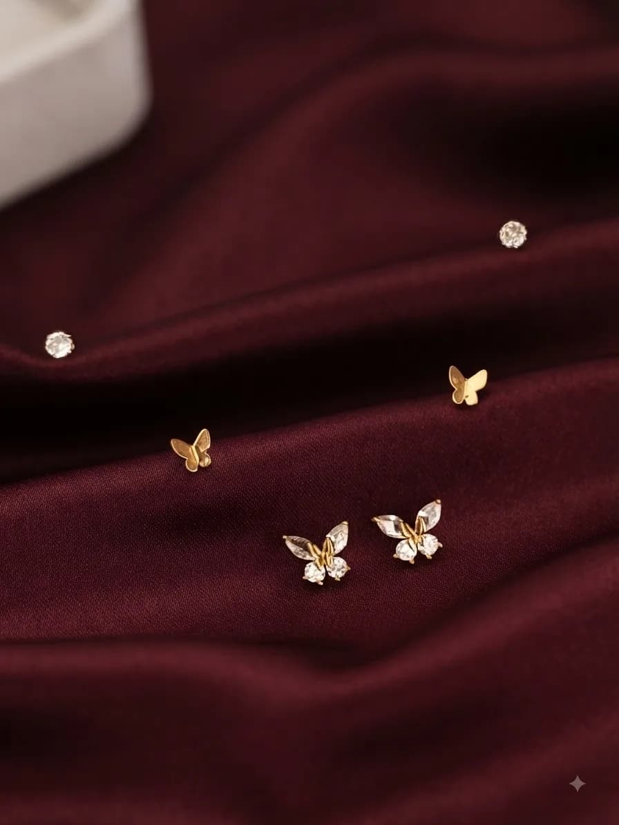 A gold-plated different set of studs, on oxblood satin