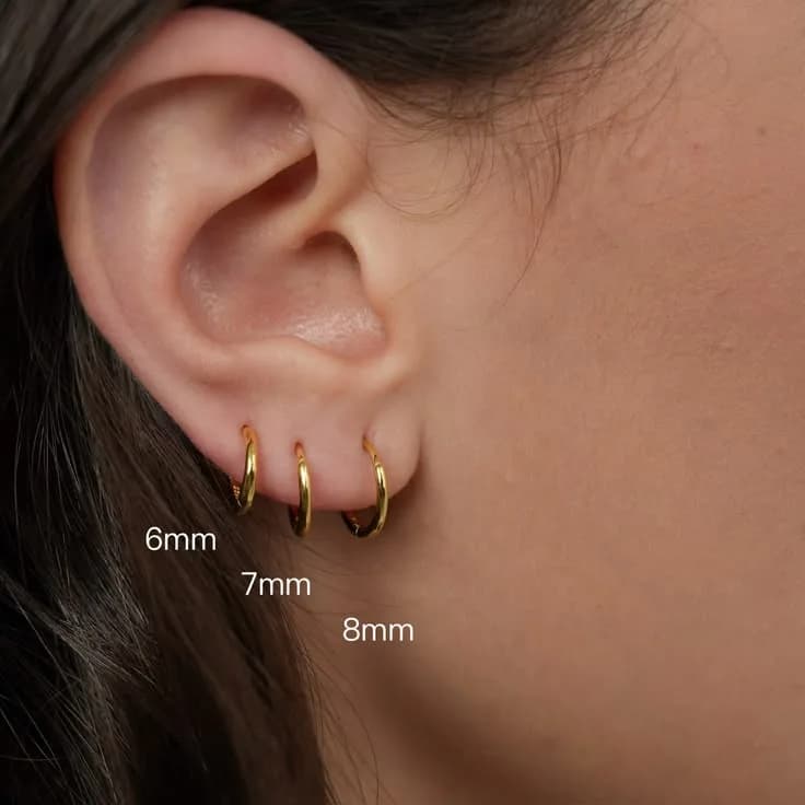 Three seamless gold-plated hoops worn in stacked ear piercings, labelled 6, 7 and 8 mm